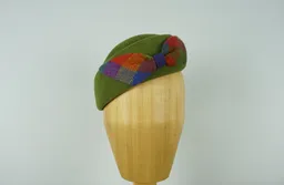 Ein vintage Beret im Erbsengrün mit einer farbenfrohen Irish Tweed Schleife.